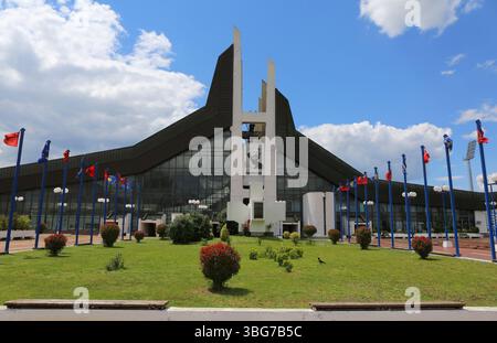 Palazzo della Gioventù e dello Sport, alias foro e edificio Ramiz con bandiere a Pristina, Kosovo Foto Stock