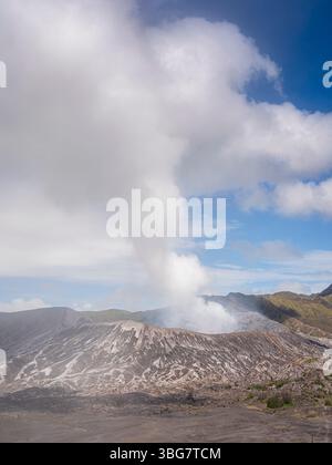 Vista verticale del vulcano attivo del Monte Bromo nella caldera di Tengger con pennacchio di fumo, Parco Nazionale di Bromo Tengger Semeru, Giava orientale, Indonesia Foto Stock
