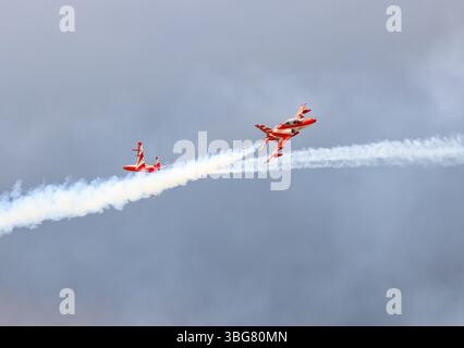 Spettacolo acrobatico dell'HAWK MK132 della squadra di aeronautica dell'India Air Force Aerobatics su formazioni con fumi colorati che fuoriescono dall'aereo. Foto Stock
