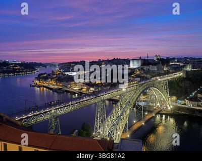 Ponte Dom Luis i illuminato di notte con tram e gente. Foto Stock