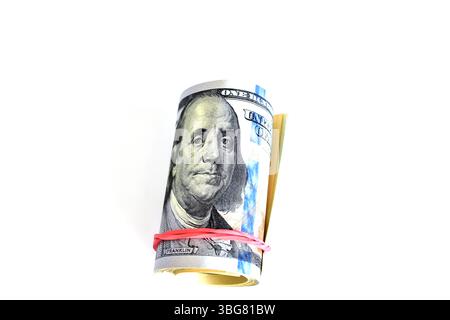 I dollari sono rotti in un tubo e i dollari legati con un elastico giacciono sul tavolo. Foto Stock