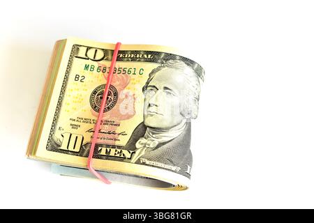 Una pila di banconote da 10 dollari, piegate a metà e legate con un elastico, giace sul tavolo. Foto Stock