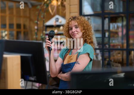 Cassiere che tiene in mano il lettore di codici a barre nel negozio di alimentari: Pronto per il pagamento Foto Stock