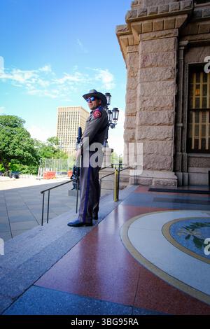 28 MAGGIO 2025 - Austin, Texas, Stati Uniti - un ufficiale di polizia militare armato a guardia dell'ingresso dell'edificio del Campidoglio di Austin in Texas Foto Stock