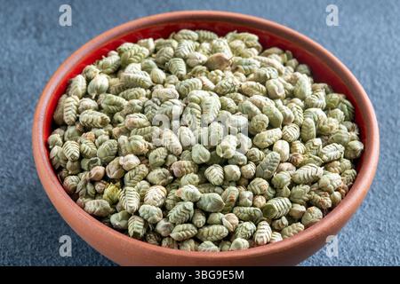 Un'abbondante quantità di semi di timo essiccati naturali su un primo piano di fondo grigio Foto Stock