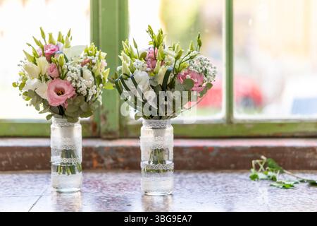 Due bouquet nuziali con lisianthus rosa e bianco e gypsophila poggiano su un davanzale Foto Stock