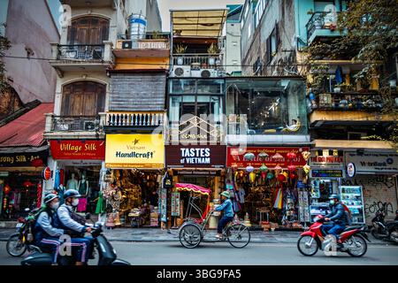 Risciò in una trafficata scena di strada nella città vecchia, Hanoi, Vietnam Foto Stock