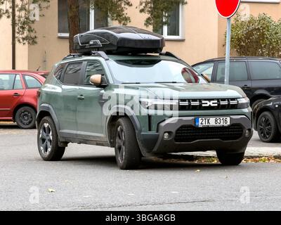 OSTRAVA, CECHIA - 9 NOVEMBRE 2024: Crossover car Green Dacia Duster III P1310 con box sul tetto parcheggiato in strada Foto Stock