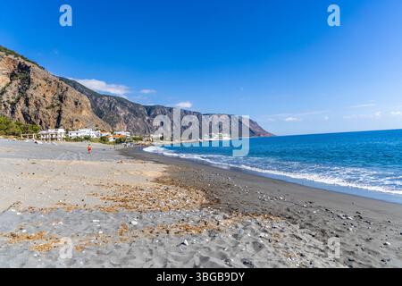 Creta, Grecia - 18 ottobre 2024: Tranquillo villaggio di Agia Roumeli sul Mar libico all'uscita della Gola di Samaria con spiaggia di ciottoli acque turchesi e. Foto Stock