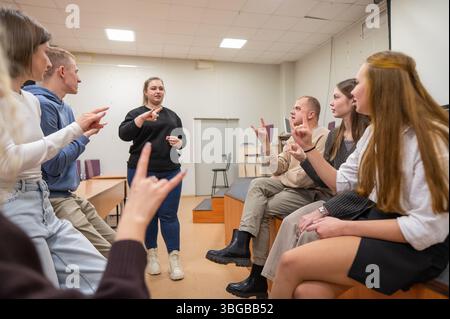I giovani comunicano in linguaggio dei segni in una classe universitaria. Foto Stock