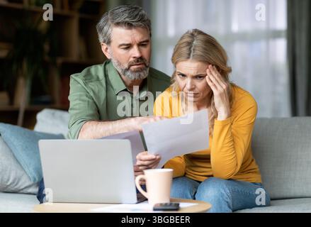 Ha sottolineato i coniugi di mezza età che hanno controllato i documenti finanziari nel paese Foto Stock