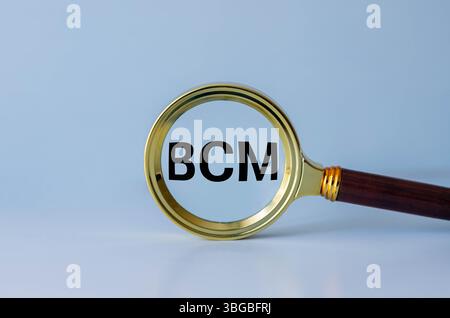 Piano di continuità aziendale BCP. sfondo in legno con testo su lente d'ingrandimento. due blocchi appunti e una calcolatrice Foto Stock