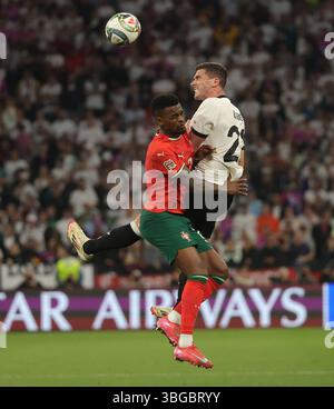 Monaco, Germania. 4 giugno 2025. Robin Gosens (R) della Germania e Nelson Semedo del Portogallo sono alla testa del pallone durante la semifinale di UEFA Nations League, partita tra Germania e Portogallo a Monaco, Germania, 4 giugno 2025. Crediti: Philippe Ruiz/Xinhua/Alamy Live News Foto Stock