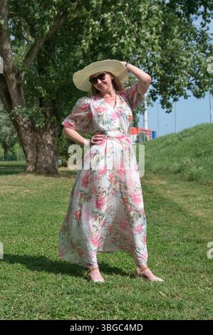 Ritratto della donna matura con cappello in piedi nel parco Foto Stock