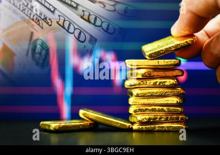 Primo piano mano fotografica che tiene una barra d'oro il grafico a candelabro e sfondo del dollaro statunitense , fluttuazioni del concetto di prezzo dell'oro Foto Stock