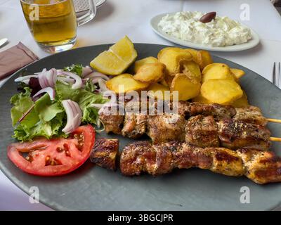 spiedini souvlaki con tzatziki e patate all'aglio Foto Stock