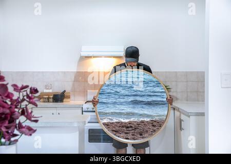 Uomo con specchio magico in cucina Foto Stock