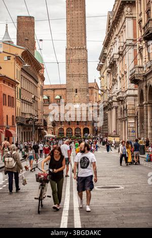 Bologna, Italia 1 gennaio 2025: Persone che camminano in via rizzoli, una delle strade principali di bologna, con le due famose torri medievali, la torre degli asi Foto Stock