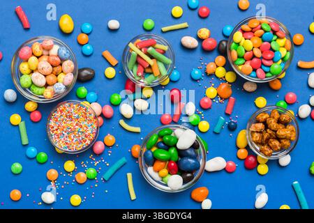 caramelle tonde di colore diverso in ciotola e vasetti. Vista dall'alto di una grande varietà di dolci e caramelle con spazio copia. Foto Stock
