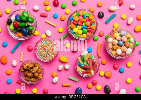 caramelle tonde di colore diverso in ciotola e vasetti. Vista dall'alto di una grande varietà di dolci e caramelle con spazio copia. Foto Stock