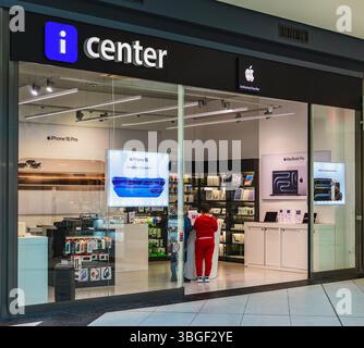Il moderno rivenditore Apple iCenter presenta iPhone 16 e MacBook Pro con eleganti display tecnologici e navigazione per i clienti. Concetto di innovazione, shopping tecnologico Foto Stock