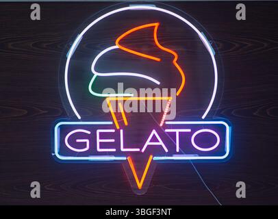 Colorato cartello gelato al neon su sfondo legno scuro Foto Stock