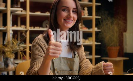 Donna caucasica sorridente decorare stoviglie dipingere argilla in laboratorio di ceramica ragazza artista designer ceramista pittore decoratore arte artigianato hobby Foto Stock