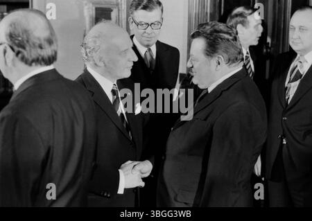Beim Neujahrsempfang des Bundespräsidenten AM 16. Januar 1976 in der Bonner Beethovenhalle begrüßt Bundespräsident Walter Scheel den CSU-Vorsitzenden und bayerischen Ministerpräsidenten Franz Josef Strauß mit einem festen Händedruck und einem Lächeln. Im Hintergrund beobachtet Franz Joachim Schoeller, der Chef des Protokolls im Auswärtigen AMT, Die Szene. Die Aufnahme zeigt das respektvolle Miteinander führender politischer Persönlichkeiten der Bonner Republik. Foto Stock