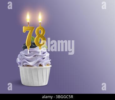 Delizioso cupcake con candele a forma di numero bruciate su sfondo viola sfumato, spazio per il testo. 78° compleanno o altra occasione speciale Foto Stock
