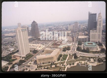 Una vista aerea dal 1990 guardando a est dal fiume Scioto verso North Downtown Columbus. Tra gli edifici degni di nota vi sono l'AEP Building, Riverside Plaza, YMCA Building, Joseph P. Kinneary Courthouse, Columbus City Hall e Leveque Tower. È visibile la costruzione del nuovo quartier generale della polizia di Columbus. Foto Stock