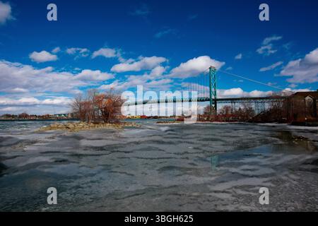 Un panoramico Ambassador Bridge che si estende graziosamente sul tranquillo fiume Detroit, catturando la tranquilla essenza della natura. Foto Stock