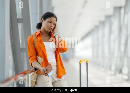 Volo perso. Ritratto della donna nera turbata in piedi all'aeroporto Foto Stock