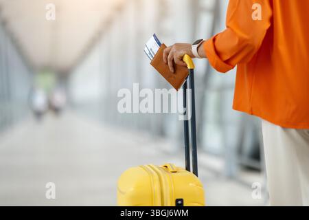 Primo piano di donne nere con passaporto e biglietti sulla maniglia della valigia Foto Stock