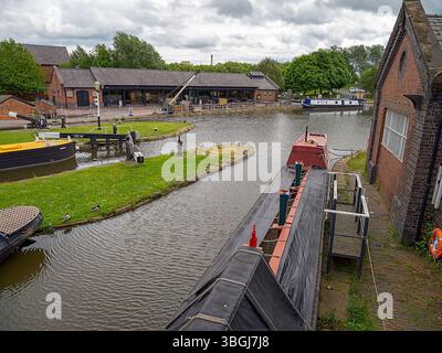 Ellesmere Port, Cheshire, Regno Unito, 05-31-2025: Museo nazionale dei corsi d'acqua. Tranquillo canale con barche strette ed edifici storici in mattoni. Foto Stock