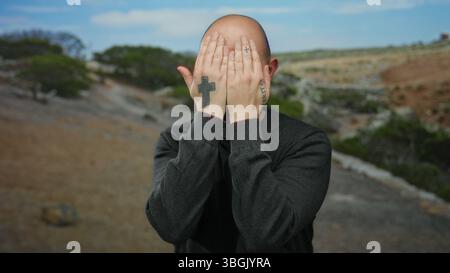 L'uomo barbuto con tatuaggi esegue gesti all'aperto in un parco panoramico mostrando espressioni giocose e interazioni con la natura. Foto Stock