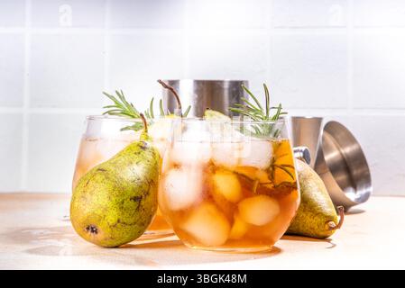 Bevanda alcolica fruttata, dolce pera fredda con rum, liquore, anice e rametto rosmarino, guarnito con pera affettata Foto Stock