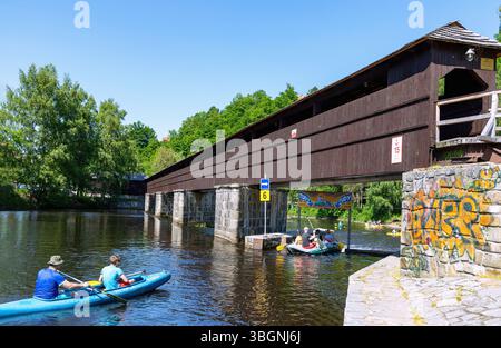 Il fiume Moldava con scivolo per barche e ponte pedonale coperto a Plesivec vicino a Cesky Krumlov nella foresta boema nella valle della Moldava nella Repubblica Ceca Foto Stock