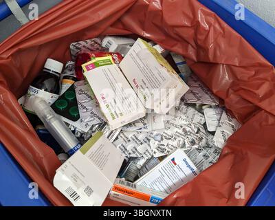 Praga, repubblica Ceca-agosto 27 2024:spreco con farmaci a volte confezioni chiuse vengono gettate via nel cestino della spazzatura speciale della farmacia. Costo della medicina inutilizzata Foto Stock