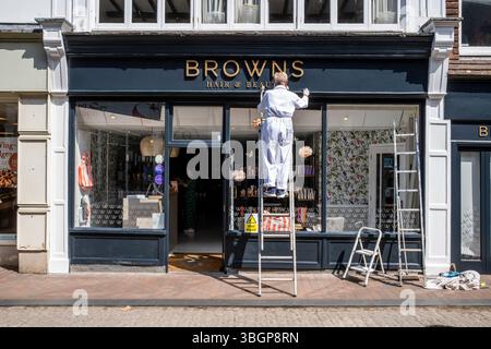 A Senior Painter and Decorator Painting A Shop Front in the High Street, Lewes, East Sussex, Regno Unito. Foto Stock