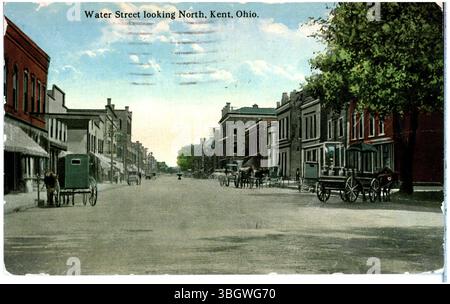 Una fotografia del 1921 di Water Street a Kent, Ohio, che mostra una vista verso nord con carri trainati da cavalli e passeggini. L'immagine fornisce un'occhiata alla strada e ai metodi di trasporto del tempo. Foto Stock