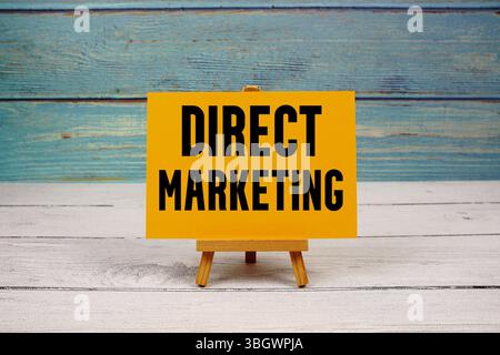 Testo di Direct Marketing scritto su carta su sfondo in legno Foto Stock