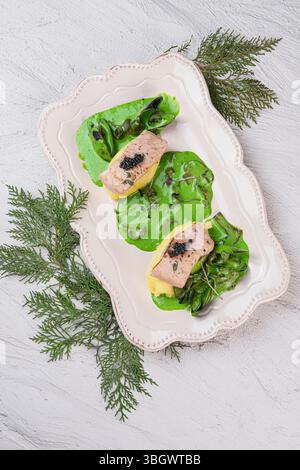 Un piatto elegante e splendidamente placcato con verdure fresche e pesce delizioso Foto Stock