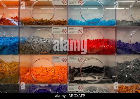 Bali, Indonesia - 17 dicembre 2024: Fila di contenitori in plastica con Lego di diversi colori. I contenitori sono pieni di Lego Foto Stock