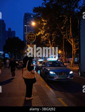 shanghai, Cina - 5 dicembre 2024 persone in attesa di taxi sulla strada di Shanghai di notte. Foto Stock