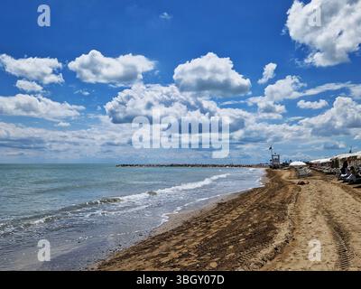 Tranquilla spiaggia con cieli limpidi e onde dolci. Lido di Jesolo, Italia Foto Stock