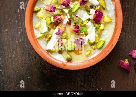 Budino di riso con condimenti completi: Miele, noci e petali di rosa. Foto Stock