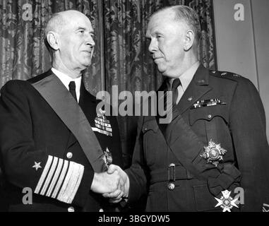 L'ammiraglio della flotta Ernest J. King (a sinistra), in pensione Capo delle operazioni navali, si congratulò con il generale dell'esercito George C. Marshall (a destra), in pensione Capo di Stato maggiore dell'esercito, dopo una cerimonia nell'ambasciata britannica, dove entrambi i capi furono onorati. Entrambi ricevettero la onorificenza di Cavaliere di Gran Croce della Divisione militare del Most Honourable Order of the Bath, che fu presentata dal Conte di Halifax, ambasciatore britannico negli Stati Uniti. 23 novembre 1945 Foto Stock