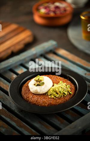 Piatto di crema knafeh, tradizionale dessert arabo mediorientale. Foto Stock