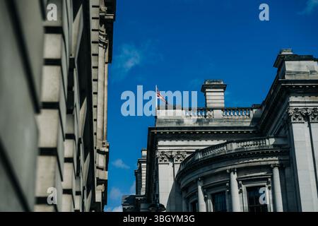 Union Jack vola sopra il classico edificio in pietra di Londra Foto Stock
