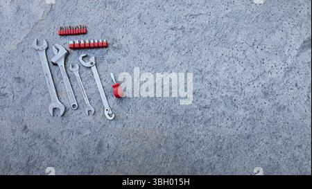Attrezzature professionali appoggiate su una superficie in calcestruzzo, pronte per l'uso per la manutenzione e la riparazione Foto Stock